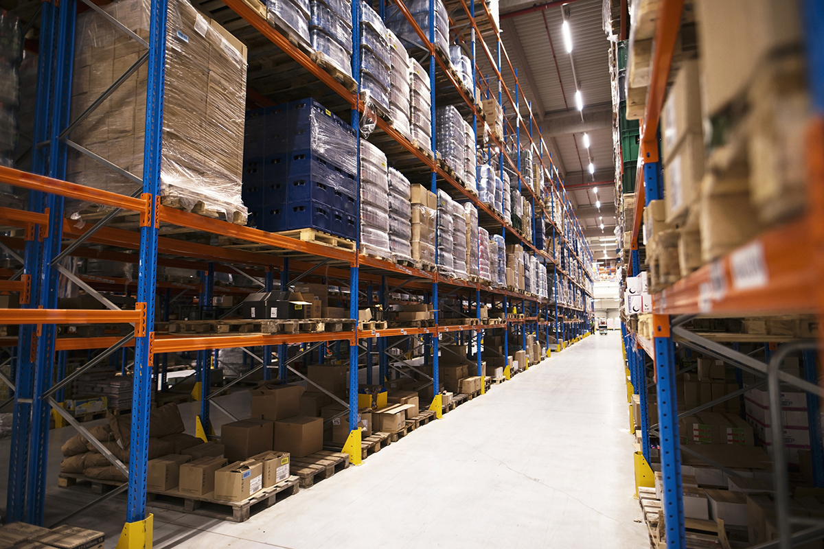 Interior of large distribution warehouse with shelves stacked wi